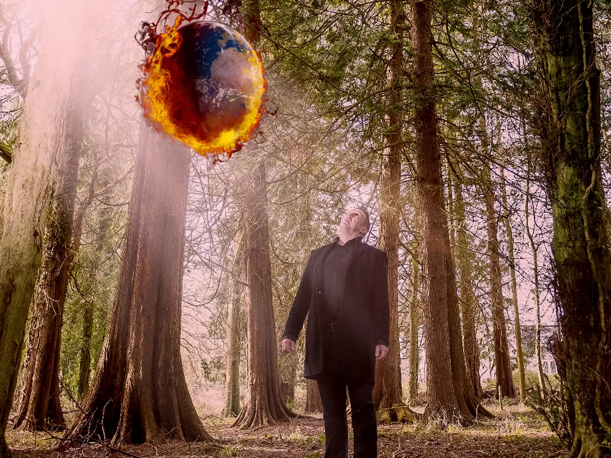 A man stunningly holds a fireball amidst the woods.