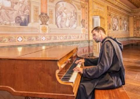 Father Robert Nixon playing piano in Celestial Void.