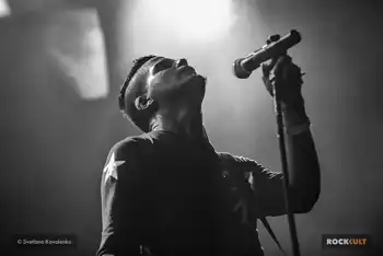 A black and white image of a man singing into a microphone.