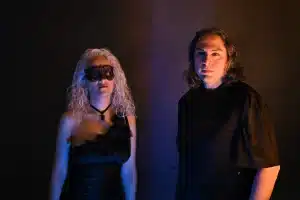 A man and a woman standing in front of a dark room.