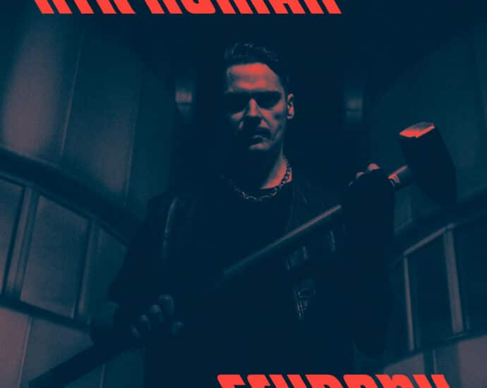 A man with a stern expression holding a sledgehammer, bathed in red lighting, with the text "xtr human - schrank" in bold font.